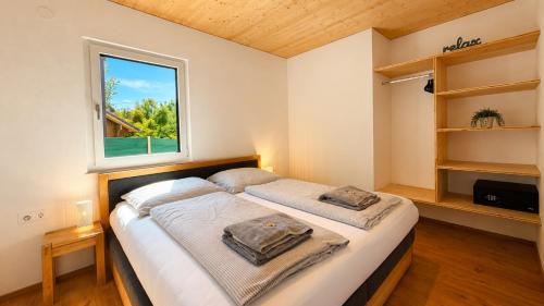 a bedroom with a large bed with a window at Apartment Relax - Stubenbergsee in Stubenberg