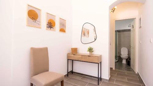 a bathroom with a table and a toilet and a mirror at Villa Frazeska in Kamares