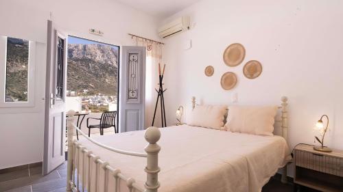 a bedroom with a white bed and a balcony at Villa Frazeska in Kamares
