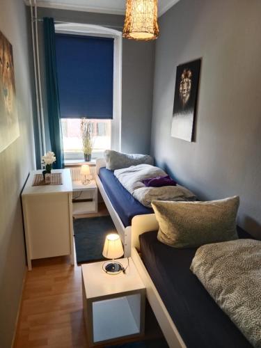 a small room with two beds and a table at Stadtnah an der Förde 65 2 in Flensburg