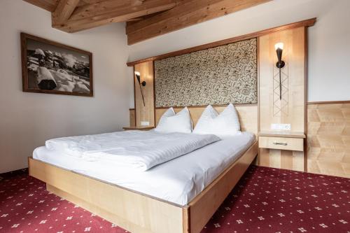 a bedroom with a large white bed in a room at ALPENAPART Ladis - Premium Family Apartments in Ladis