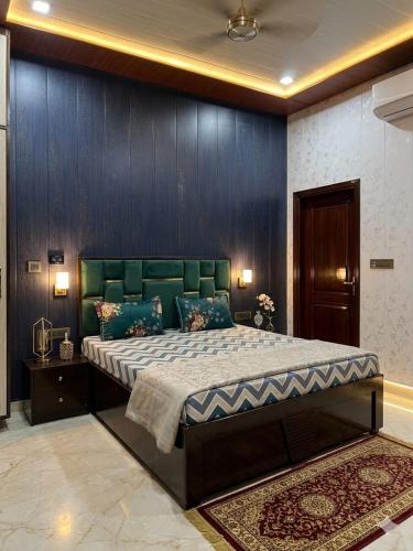 a bedroom with a large bed with a green headboard at Hotel Shree Sanwaliya INN in Ayodhya