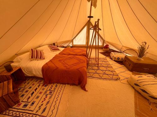a bedroom with a bed in a tent at Glamping Luz Olive in Combret