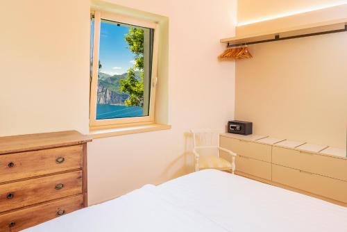 a bedroom with a bed and a window at Chalet Ca' la Fratela in Malcesine