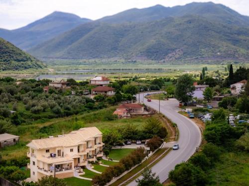 a village with a road and mountains in the background at Ithaki Apartments in Paramythia
