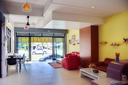 a living room with a red couch and a table at At Home Khaolak in Khao Lak