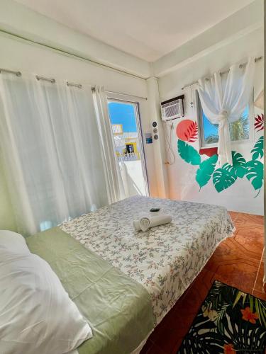 a bedroom with a bed and a window at Bulan Guesthouse in San Isidro