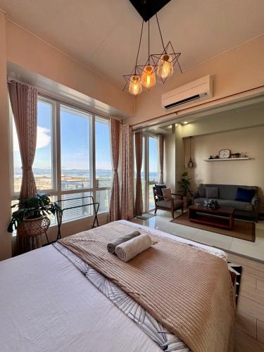 a bedroom with a large bed with a large window at Luxe Gold Mactan in Mactan