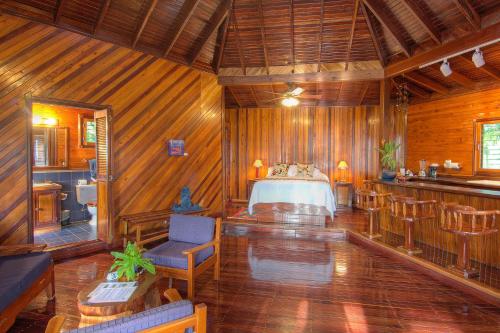 a bedroom with a bed in a wooden room at Tambor Tropical Beach Resort- Adults Only in Tambor