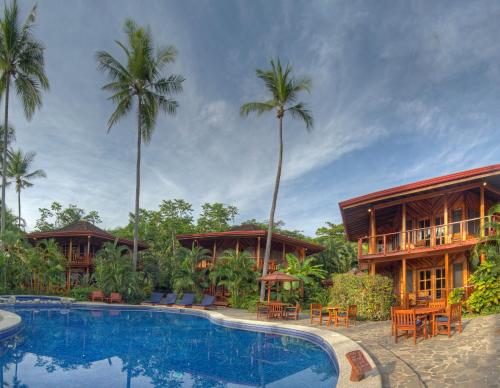 a resort with a swimming pool and palm trees at Tambor Tropical Beach Resort- Adults Only in Tambor