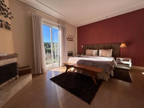 a bedroom with a large bed and a large window at Pousada Annecy - CAPIVARI Fácil acesso ao centrinho e Baden Bar in Campos do Jordão