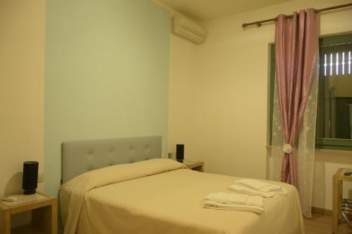 a bedroom with a bed with white sheets and a window at La Tana Del Cinghiale in Tirli