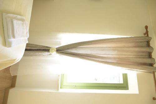 a window in a room with a curtain at La Tana Del Cinghiale in Tirli
