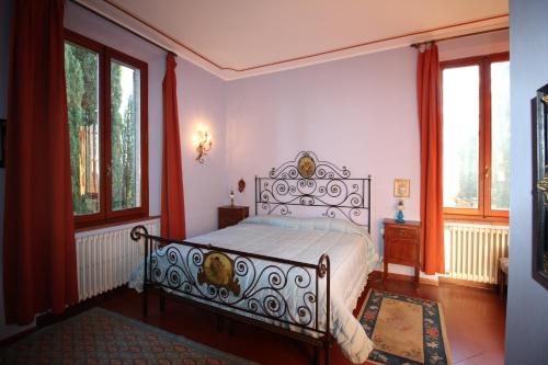 a bedroom with a bed in a room with windows at Villa Larniano in Siena