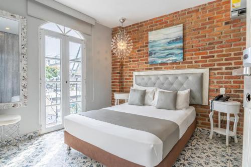 a bedroom with a brick wall and a bed at Hotel Boutique ADAZ in Santa Marta