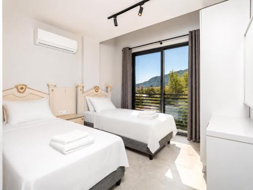 two beds in a room with a large window at Villa Exclusive Paradise 2 in Dalyan