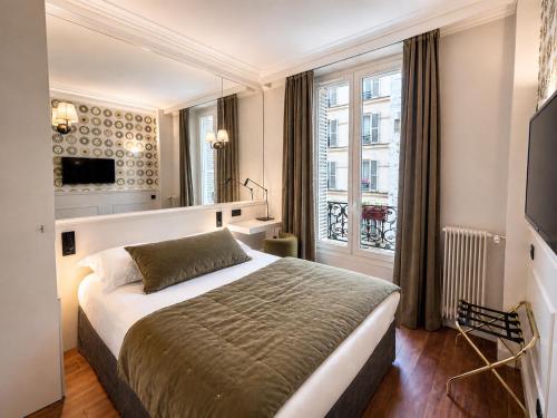a bedroom with a large bed and a window at Hotel des Bains in Paris