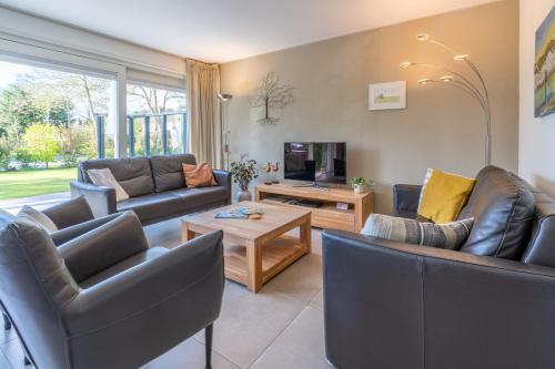 a living room with two couches and a tv at Landhuis Tempelierweg 23 in Den Burg
