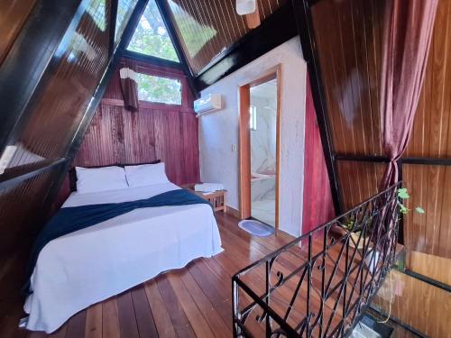 a bedroom with a bed in a room with a window at Chalé da lagoa in Lagoa Santa