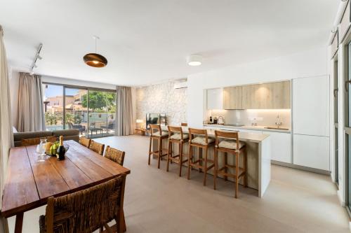 a kitchen and living room with a wooden table and chairs at PANKI Beach Villa Protaras in Protaras