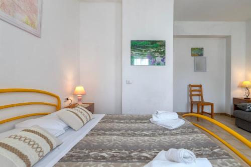 a bedroom with a large bed and a chair at Appartamenti Abbaidda 4 in Valledoria