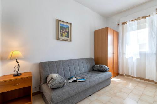 a living room with a couch with a book on it at Appartamenti Abbaidda 4 in Valledoria