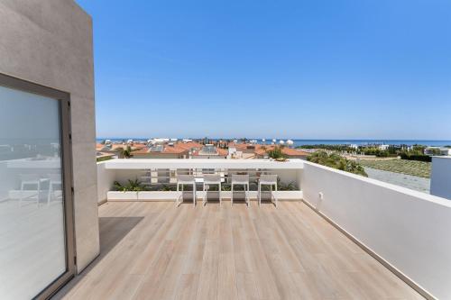 a balcony with chairs and a view of the ocean at PANKI Beach Villa Protaras in Protaras