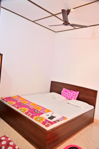a bed with a wooden frame and a pink pillow at SUN SHINE RESORT in Neil Island