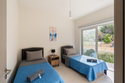 a bedroom with two beds and a window at The Icon 001 - Superior 2BR Apartment with Pool & Gym, Mythical Seas - Protaras in Paralimni
