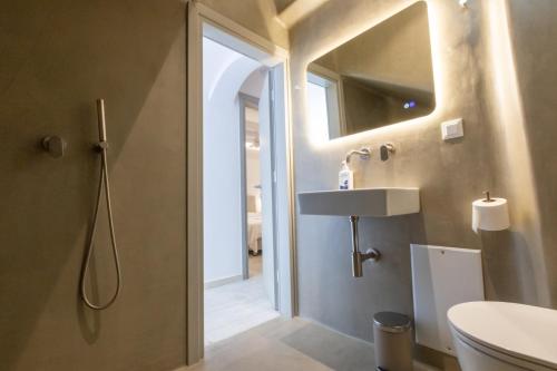 a bathroom with a toilet and a sink and a mirror at Villa Evita Panormos private pool & jacouzzi in Mykonos