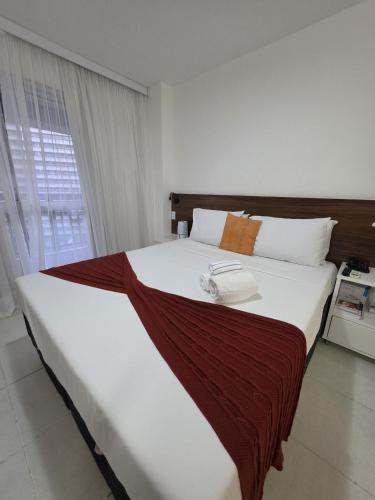 a bedroom with a large bed with a phone on it at Flat perto da Esplanada | SHN in Brasília