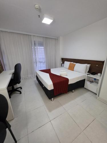 a bedroom with a bed and a desk in it at Flat perto da Esplanada | SHN in Brasília