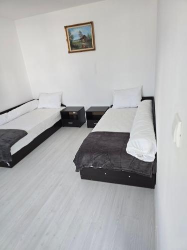 two beds in a white room with at Вила Стоянови in Yasen