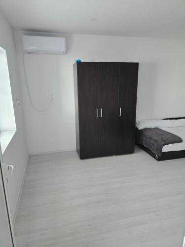a room with a bed and a cabinet in it at Вила Стоянови in Yasen
