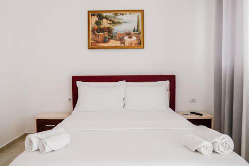 a bedroom with a white bed with two pillows at Vila Finnley in Ksamil