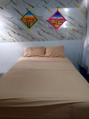 a white bed with three kites on the wall at Kaigeemayapo in Manaure