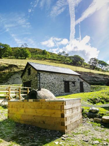 an old stone building with a stone oven in a field at Cwm Clyd - Carthouse in Rhayader