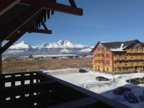 uma vista a partir da varanda de um alojamento de turismo selvagem com montanhas cobertas de neve em Apartmán Fiona em Veľká Lomnica