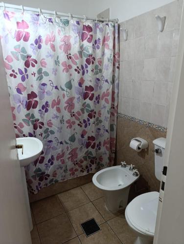 a bathroom with a shower curtain with a toilet and a sink at Hotel de Campo con Piscina y Cabañas- Ideal Relax en Concordia in Concordia