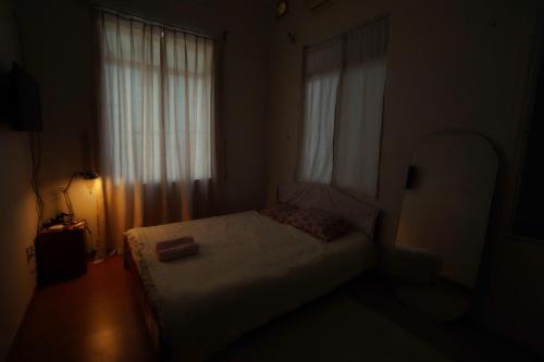 a small bedroom with a bed and a window at Pawseas Homestay in Danang