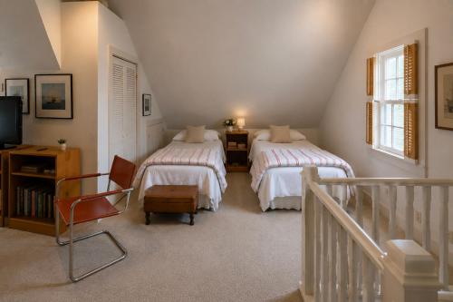 a attic bedroom with two beds and a television at 29 India House in Nantucket