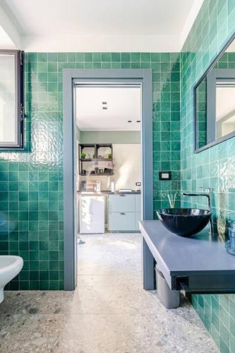 a green tiled bathroom with a sink and a mirror at Walk to Fly Gate 65 Appartaments in Naples