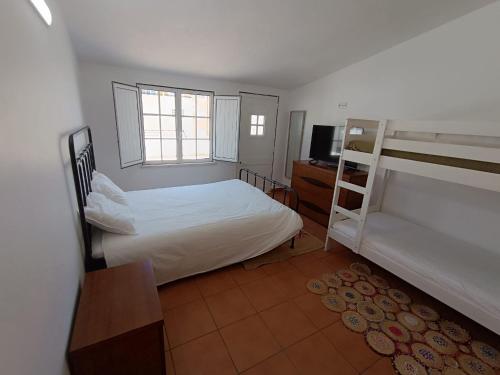 a bedroom with two bunk beds and a television at Casinha do Rui in Sines