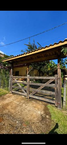 a wooden fence with a gate in front of a house at Casa na Serra Canto do Jair in Casimiro de Abreu