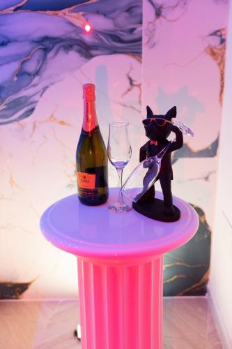 a pink table with a bottle and a wine glass at DRM Bed&Breakfast in Marcianise