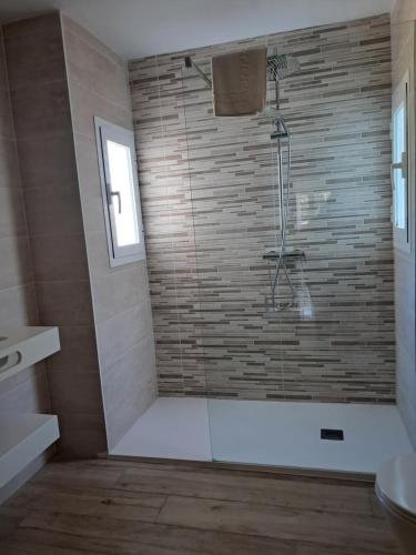 a bathroom with a shower with a glass door at Apartamentos Cala Llonga in Cala Llonga