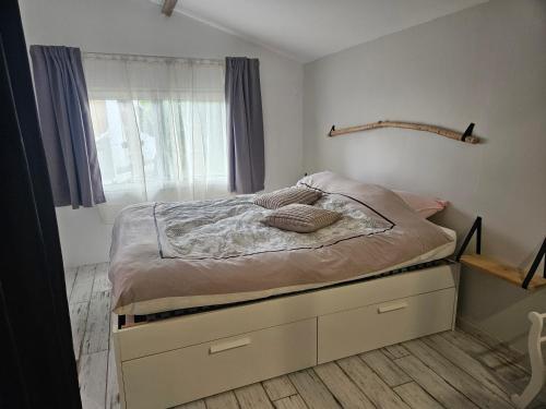 a bedroom with a bed with a large window at Ici et nulle part ailleurs in Saint-Vivien-de-Médoc
