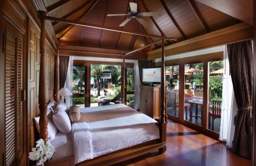a bedroom with a canopy bed and a patio at Amari Vogue Krabi in Tab Kaek Beach