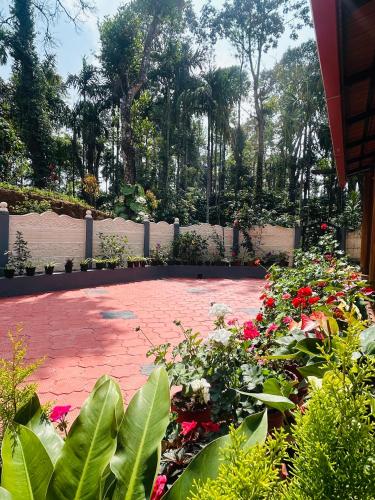 a garden with flowers and a brick patio at Priyaman Retreat in Madikeri