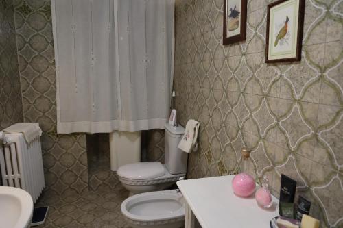 a bathroom with a white toilet and a sink and a toilet istg at Casa di Sergio in Gambassi Terme